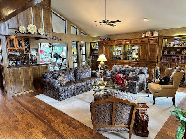 living room featuring ceiling fan, bar, high vaulted ceiling, and light hardwood / wood-style floors