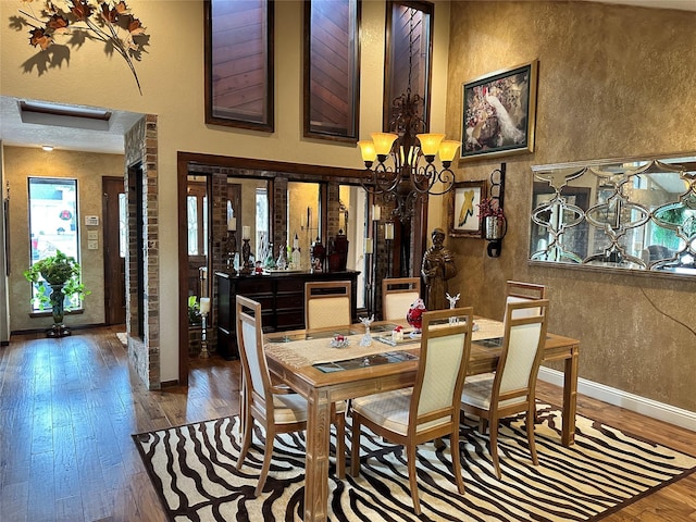 dining room with hardwood / wood-style flooring and a chandelier