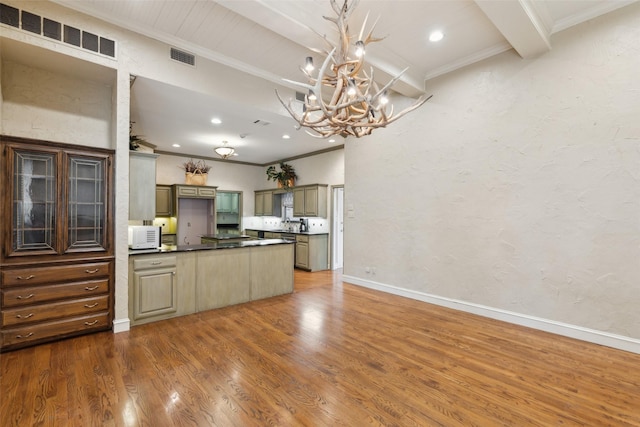 kitchen featuring beam ceiling, hardwood / wood-style floors, crown molding, and a notable chandelier