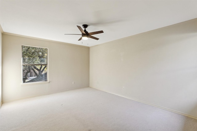 carpeted empty room featuring ceiling fan and ornamental molding