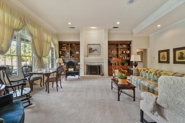 carpeted living room featuring crown molding, built in features, and a tile fireplace