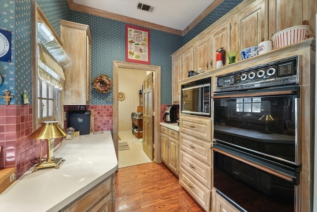 kitchen featuring crown molding, light brown cabinetry, light wood-type flooring, and black appliances