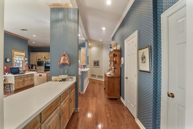 hallway with ornamental molding and hardwood / wood-style floors