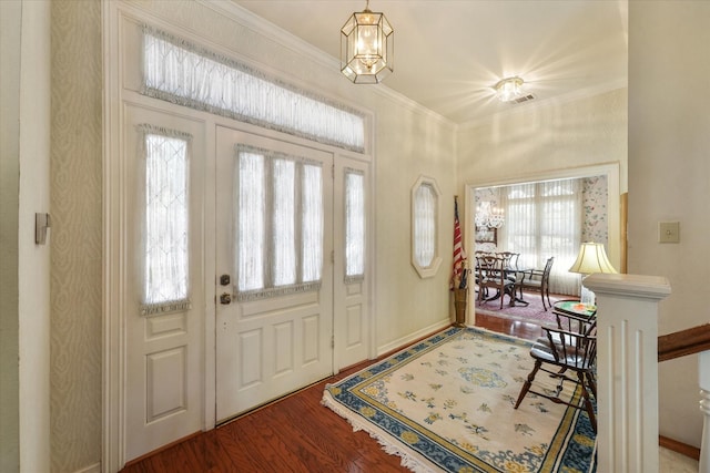 foyer featuring wood-type flooring and crown molding