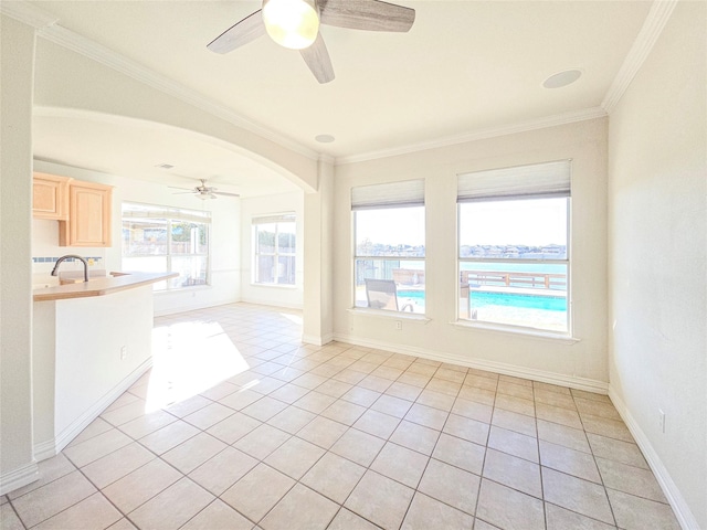 unfurnished room featuring light tile patterned floors, crown molding, sink, and ceiling fan