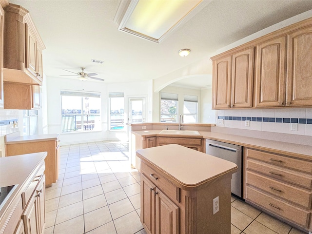 kitchen with sink, stainless steel dishwasher, a center island, and light tile patterned flooring