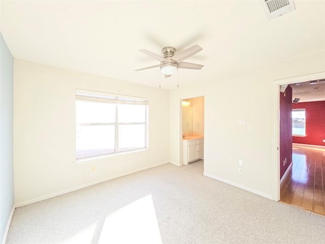 spare room with ceiling fan and light colored carpet