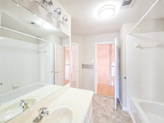 bathroom with vanity, shower / washtub combination, and a textured ceiling