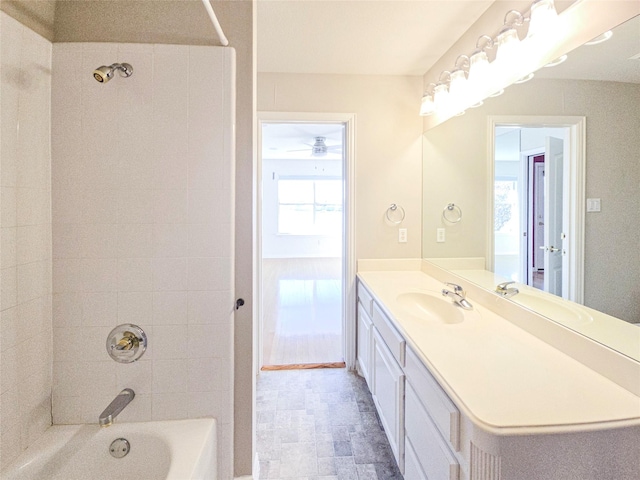 bathroom featuring tiled shower / bath combo, vanity, and a wealth of natural light