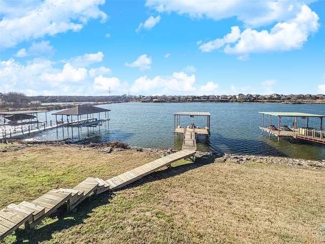 view of dock with a water view and a yard