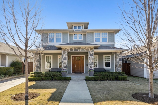 prairie-style home featuring a front lawn and covered porch