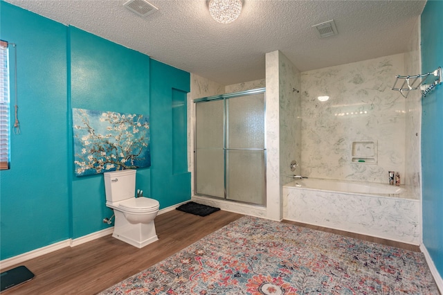 bathroom featuring independent shower and bath, hardwood / wood-style floors, a textured ceiling, and toilet