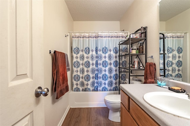 full bathroom with hardwood / wood-style floors, vanity, shower / bath combination with curtain, a textured ceiling, and toilet