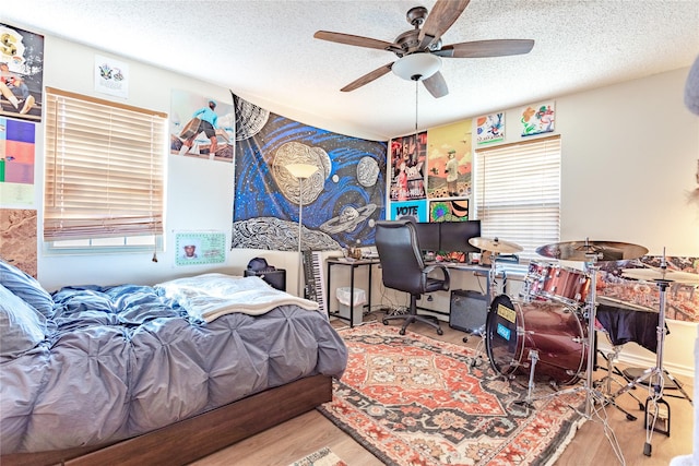 bedroom featuring ceiling fan, multiple windows, and a textured ceiling