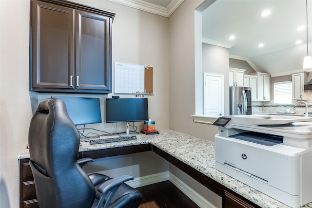 office space featuring dark hardwood / wood-style flooring, built in desk, vaulted ceiling, and ornamental molding