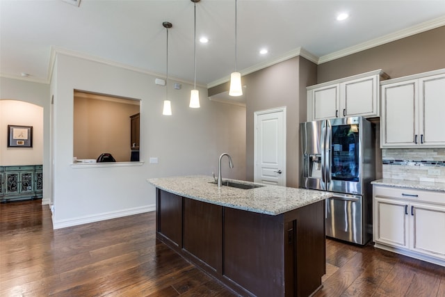 kitchen featuring white cabinetry, sink, light stone countertops, and stainless steel refrigerator