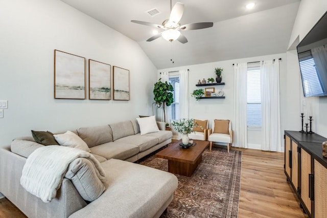 living room with ceiling fan, vaulted ceiling, and wood-type flooring