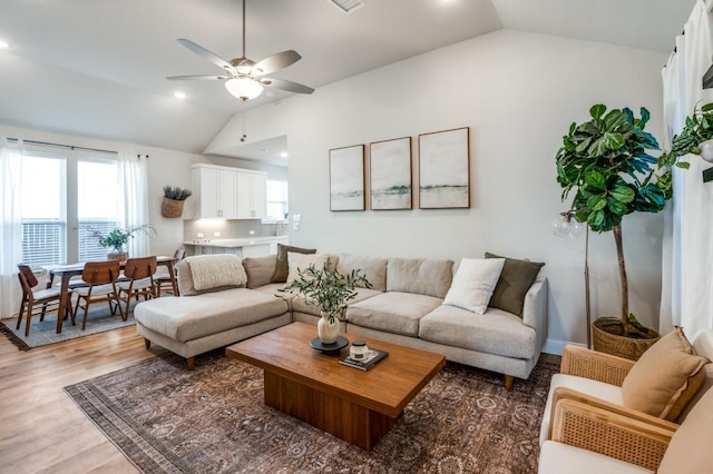 living room with wood-type flooring, lofted ceiling, and ceiling fan