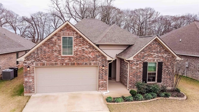 view of front property featuring a garage, cooling unit, and a front lawn