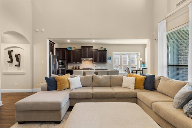 living room featuring a towering ceiling and light hardwood / wood-style floors