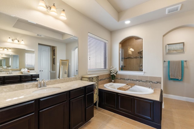 bathroom with tile patterned flooring, vanity, a tray ceiling, and plus walk in shower