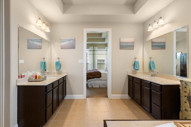 bathroom with vanity, tile patterned floors, and a raised ceiling