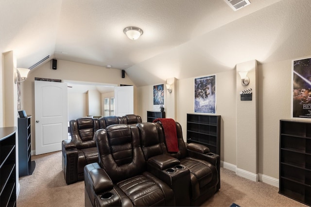 cinema with lofted ceiling and light colored carpet