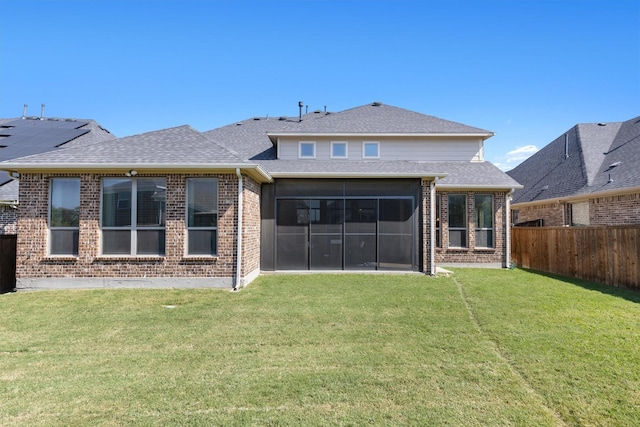 rear view of property featuring a sunroom and a lawn