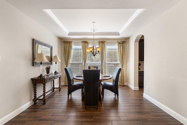 dining room with a raised ceiling and a chandelier