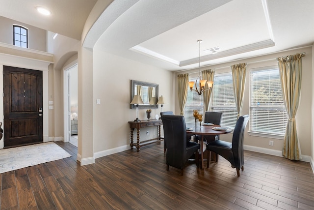 dining room with dark hardwood / wood-style flooring and a tray ceiling