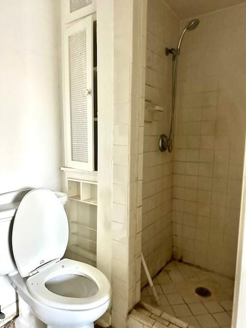 bathroom featuring tiled shower and toilet