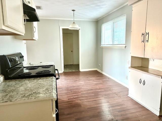 kitchen featuring dark wood-type flooring, hanging light fixtures, ornamental molding, white cabinets, and black / electric stove