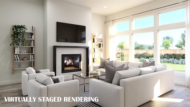 living room featuring a brick fireplace, a wealth of natural light, and light hardwood / wood-style floors