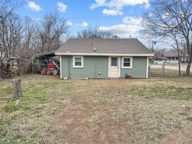 back of property with a lawn and a carport