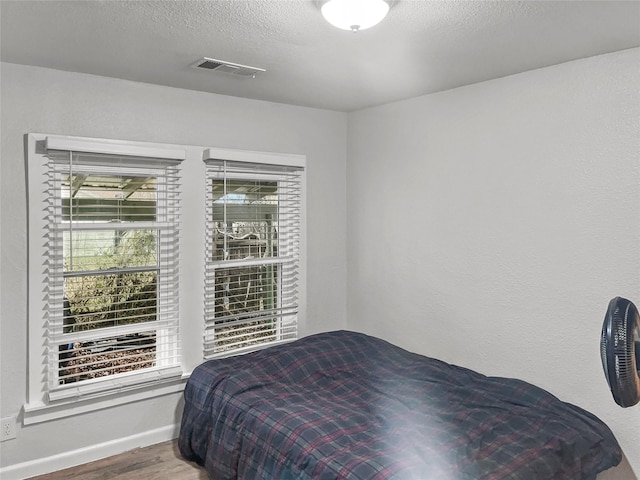 bedroom featuring hardwood / wood-style floors and a textured ceiling