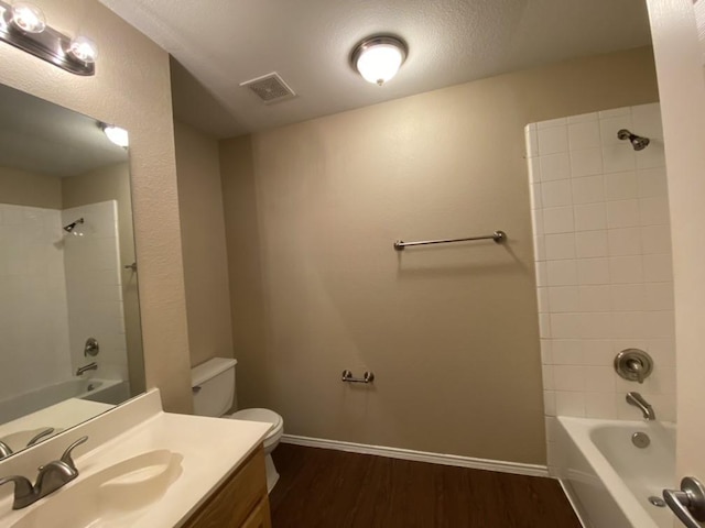 full bathroom featuring tiled shower / bath combo, wood-type flooring, vanity, and toilet