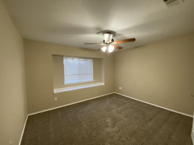 empty room featuring ceiling fan and dark carpet