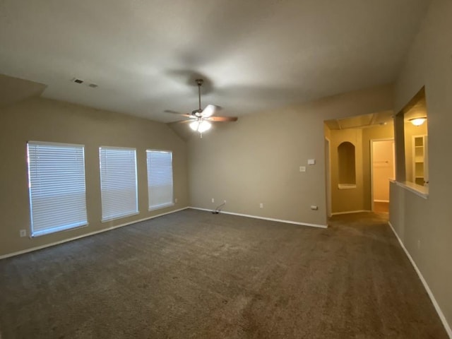 empty room with lofted ceiling, dark carpet, and ceiling fan