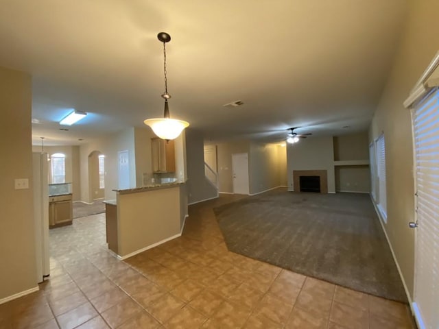 kitchen with hanging light fixtures, light brown cabinets, white refrigerator, kitchen peninsula, and ceiling fan