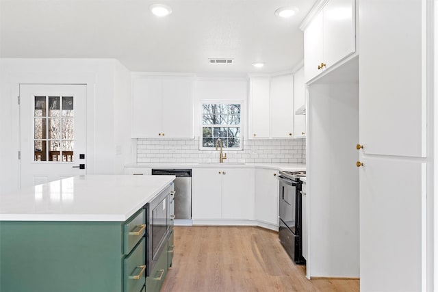 kitchen featuring sink, green cabinetry, dishwasher, black range with electric cooktop, and white cabinets