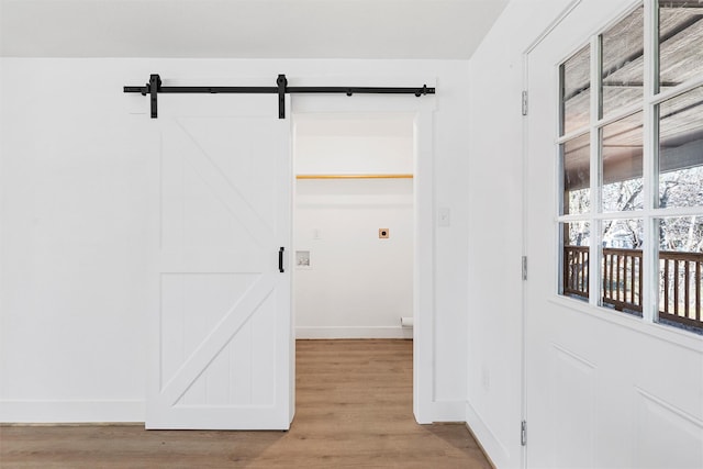 interior space with a barn door and light wood-type flooring