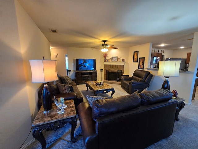 carpeted living room with a brick fireplace and ceiling fan