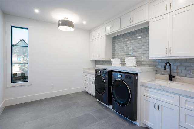 washroom featuring separate washer and dryer, sink, and cabinets