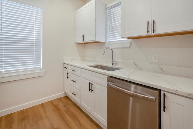 kitchen with sink, white cabinetry, light stone counters, light hardwood / wood-style floors, and stainless steel dishwasher