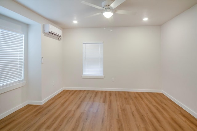 spare room featuring ceiling fan, light hardwood / wood-style flooring, and an AC wall unit