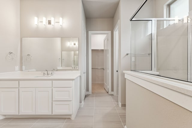 bathroom featuring a shower with door, vanity, and tile patterned floors