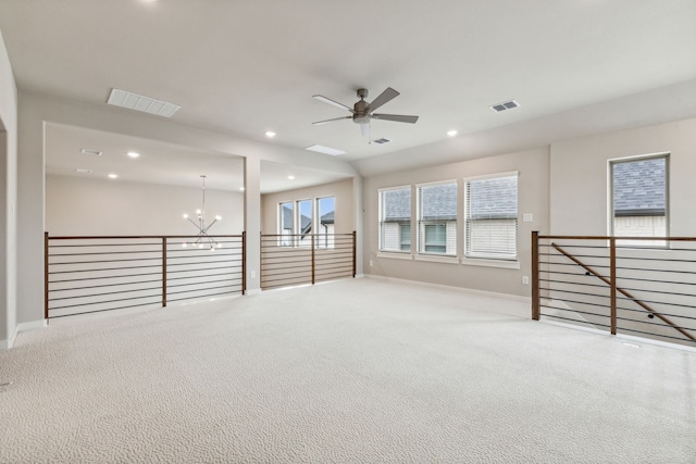 basement featuring ceiling fan with notable chandelier and light colored carpet