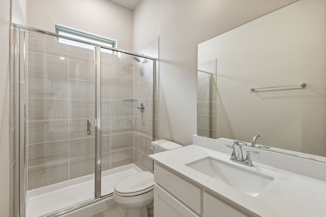 bathroom with vanity, a shower with shower door, and toilet