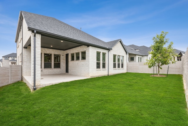 rear view of house with a patio and a lawn