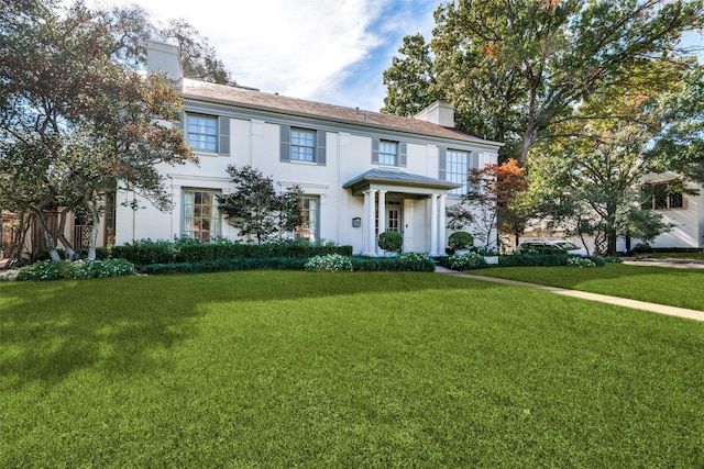 colonial-style house featuring a front yard